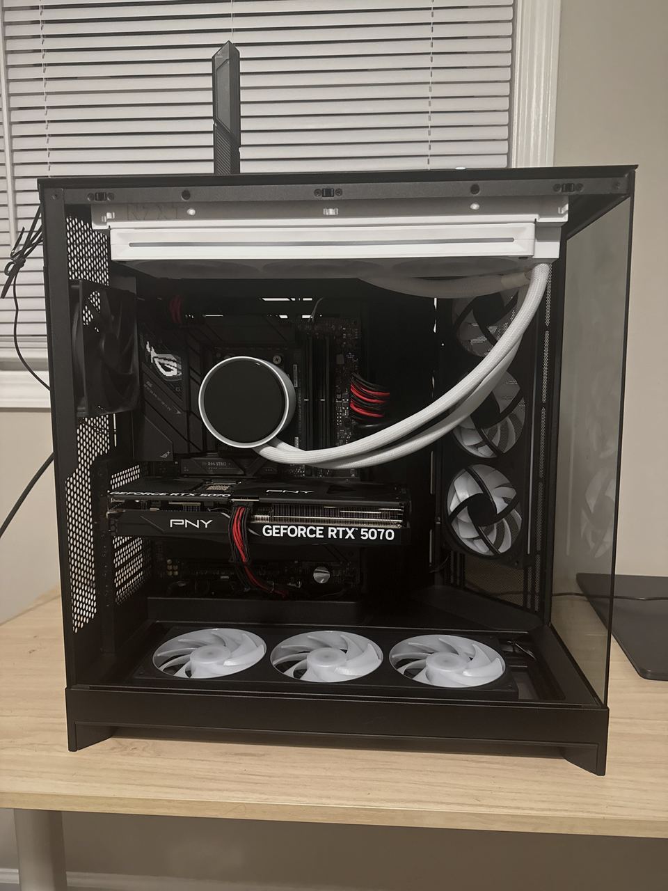 The same custom PC with the lighting off, showing the cable routing, white cooler tubing and graphics card.